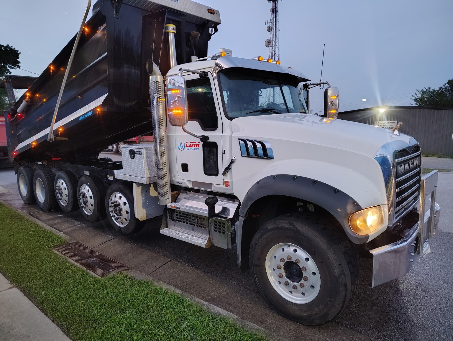 White LDM Transport Mack dump truck at dusk
